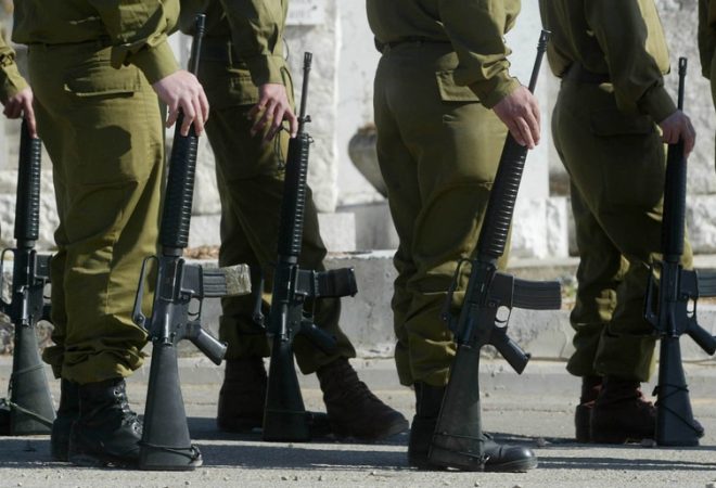 PETAKH TIKVA, ISRAEL - APRIL 4: Israeli soldiers wait for the body of Kobi Zaga to be brought for burial April 4, 2004 during his funeral at the Segula grave yard close to the city of Petakh Tikva, Israel. Zaga was killed two days ago when a Palestinian militant entered the settlement of Avnei Hefez, close to the West Bank city of Tulkarem, and opened fire before being gunned down by Israeli troops.