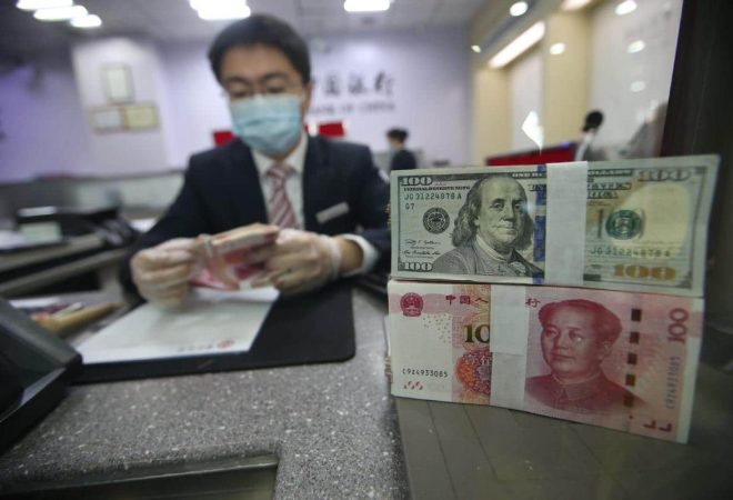 A teller counts currency at a bank branch in Taiyuan, Shanxi province China News Agency