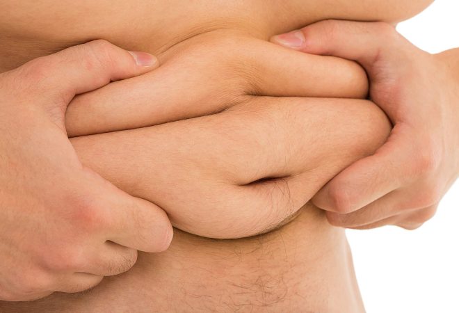 Man is holding his too fat tummy