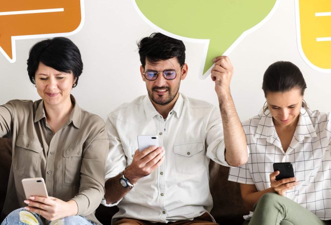 Co-workers sitting on couch and holding message icons