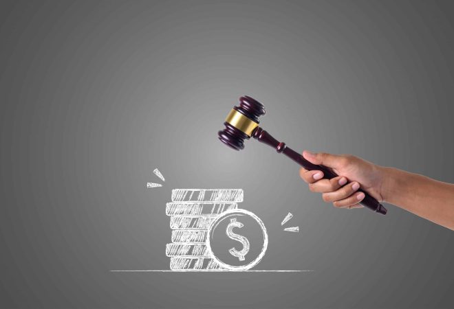The hand that holds the hammer and piles of money written with white chalk, draw concept.