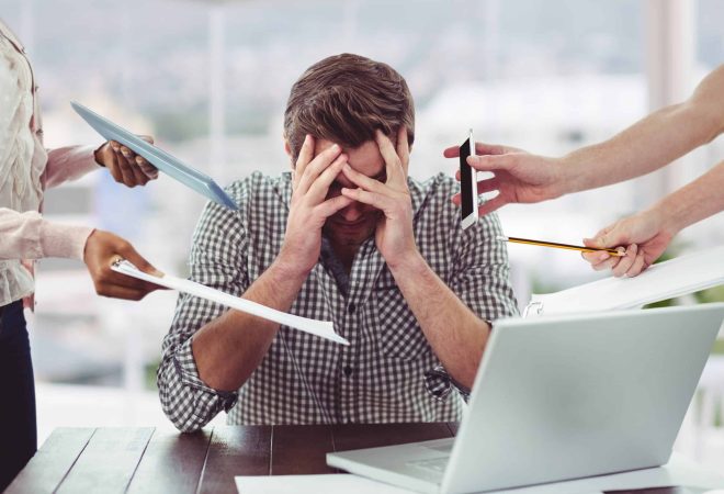 Stressed man frustrated with electronic devices in office