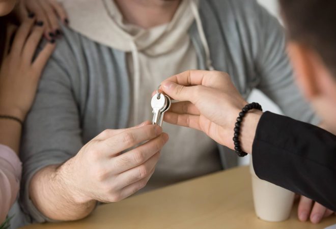 Realtor giving couple keys to own home, family customers buying new house or rent apartment concept, making real estate deal or property ownership, mortgage loan investment, close up view of hands