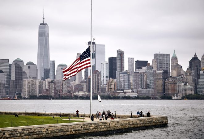 An amazing shot of the US flag in a park on the Manhattan skyline background