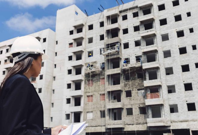 americano-africano-senhora-em-capacete-seguranca-com-papeis-perto-predios-construcao