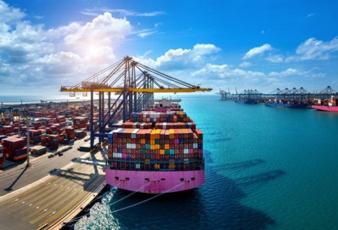 Aerial view of cargo ship and cargo container in harbor.