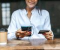 Pay for goods by credit card through a smartphone in a coffee shop.