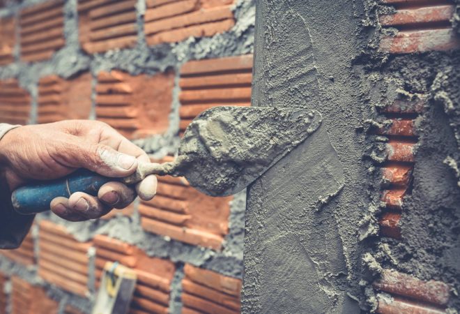 Bricklaying. Construction worker building a brick wall.