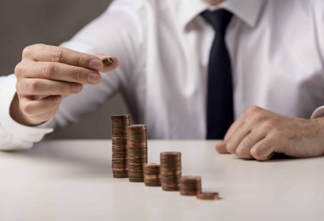 businessman-adding-coin-stack