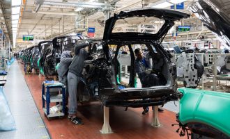 Car bodies are on assembly line. Factory for production of cars. Modern automotive industry. A car being checked before being painted in a high-tech enterprise.