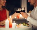 Cropped photo of young lovers having romantic dinner and drinking red wine at home