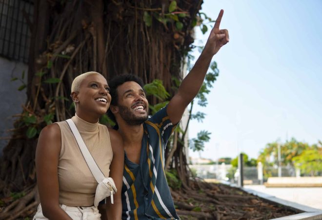 casal-sorridente-em-foto-media-ao-ar-livre