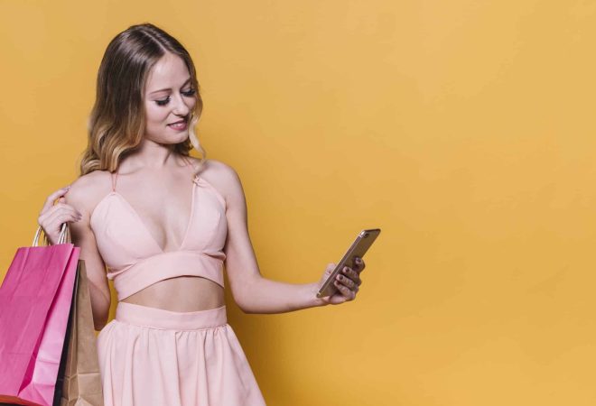 charming-woman-with-bags-using-phone