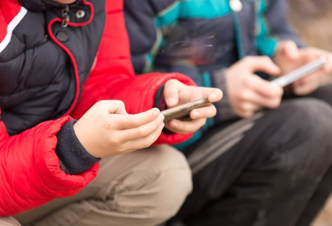 Boy playing computer games on a cell phone .