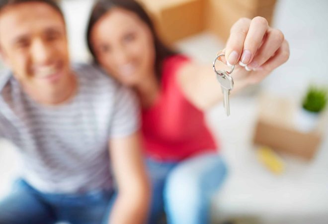 Hand of young woman showing key from new flat