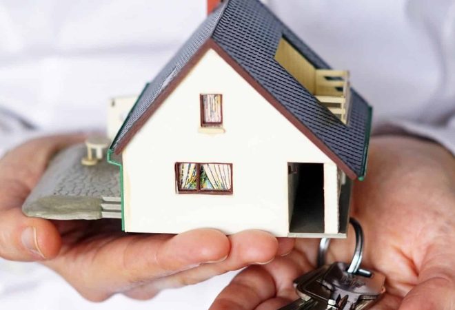 A vertical closeup shot of a person thinking of buying or selling a house