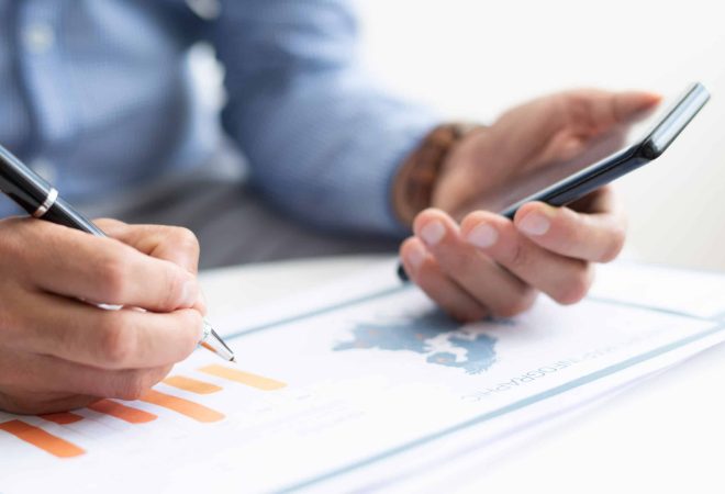 Closeup of business man working with diagram. Map infographics study. Technology and information concept. Cropped view.