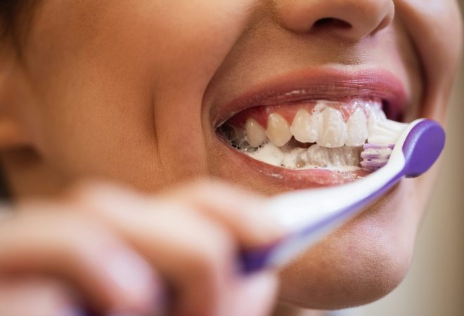 Close-up of woman brushing her teeth.