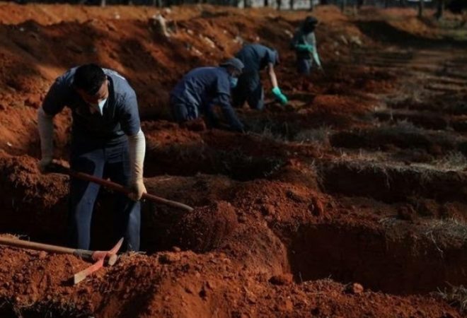 FILE PHOTO: Gravediggers wearing protective face masks dig new graves at Vila Formosa cemetery amid the outbreak of the coronavirus disease (COVID-19) in Sao Paulo, Brazil, August 6, 2020. REUTERS/Amanda Perobelli/File Photo