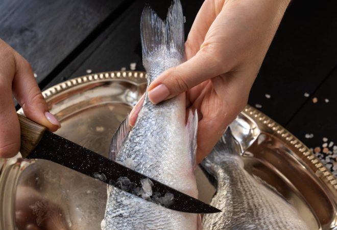 cozinheiro-de-vista-superior-limpando-peixe-na-cozinha
