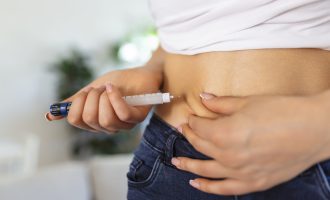 A diabetic patient using insulin pen for making an insulin injection at home. Young woman control diabetes. Diabetic lifestyle