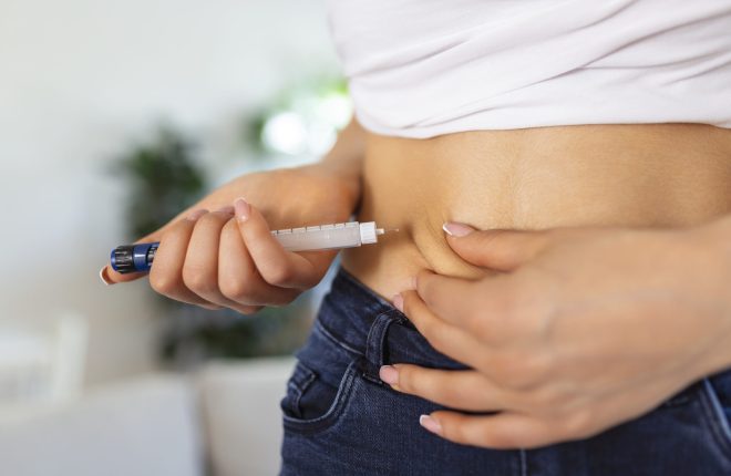 A diabetic patient using insulin pen for making an insulin injection at home. Young woman control diabetes. Diabetic lifestyle