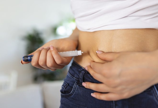 A diabetic patient using insulin pen for making an insulin injection at home. Young woman control diabetes. Diabetic lifestyle