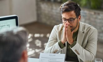 Distraught young man feeling uncertain while having a job interview in the office.