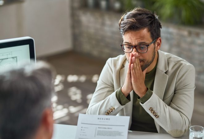 Distraught young man feeling uncertain while having a job interview in the office.