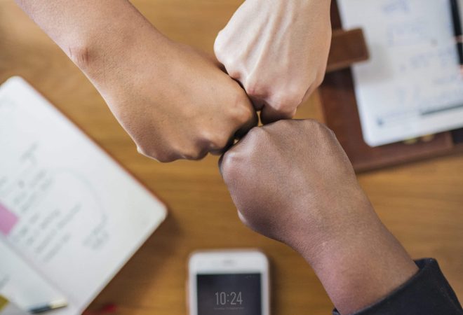 Diverse people giving a fist bump