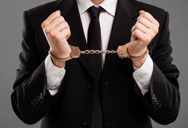 Businessman in suit with closed manacles on his hands