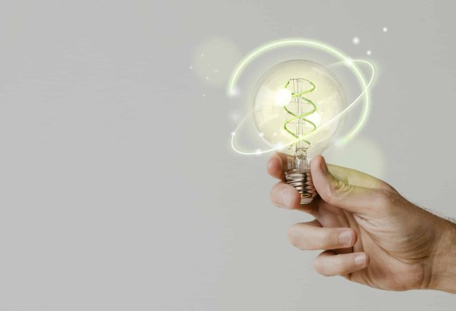 Green energy with hand holding an environmental light bulb background