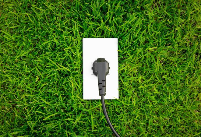 Energy concept outlet in fresh spring green grass