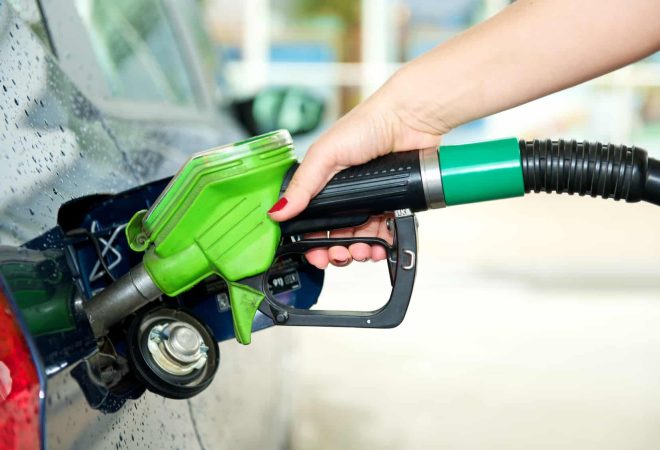 Frau tankt Auto an Tankstelle