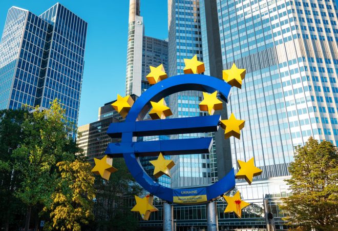 Close view of The Euro-Skulptur with multiple skyscrapers on the background in Frankfurt downtown, Germany. Flag of Ukraine and blood on it