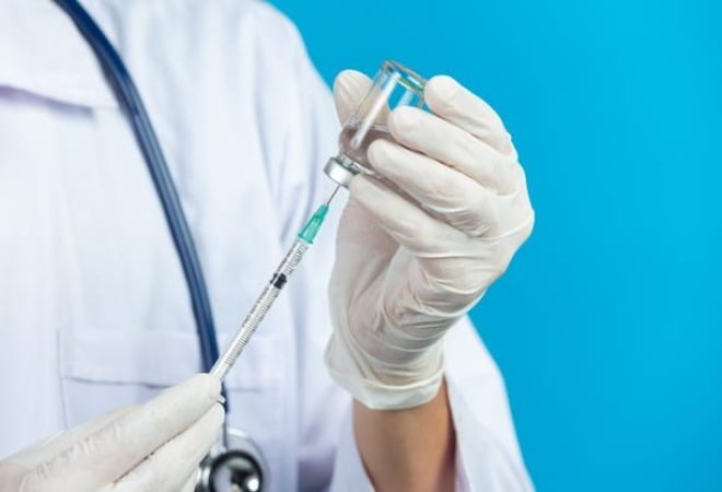 feche-a-foto-das-maos-do-medico-segurando-uma-seringa-hipodermica_1150-26688