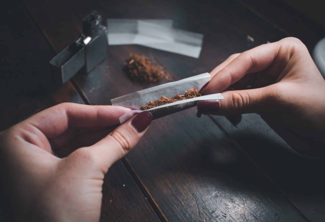 A high angle shot of a female rolling a joint