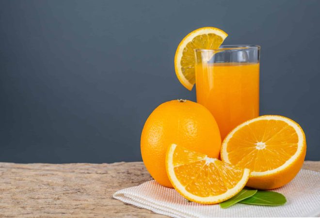 Glass of orange juice placed on wood.