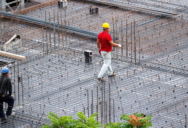 Construction building workers working at the site in a cloudy day