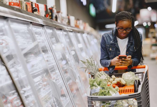African woman with shopping cart. Girl in a supermarket.