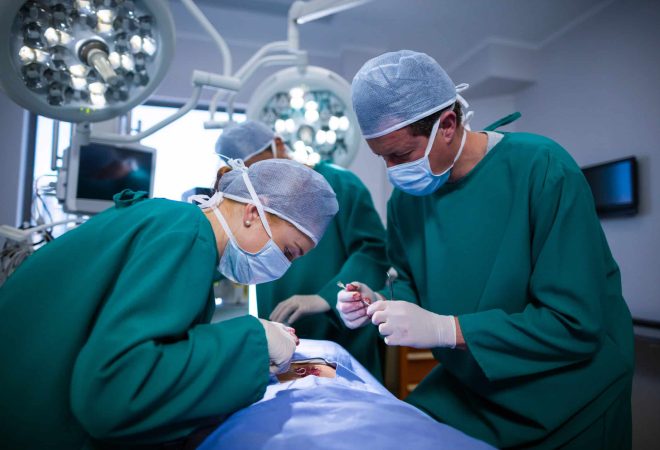 Surgeons performing operation in operation theater of hospital