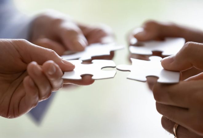 Close,Up,Hands,Of,Four,Businesspeople,Hold,Pieces,Of,White