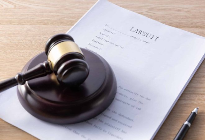 high-angle-shot-of-a-gavel-and-lawsuit-papers-on-a-wooden-surface