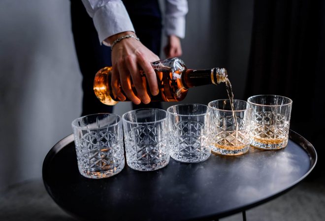 Man is pouring the strong alcohol drink into the glass
