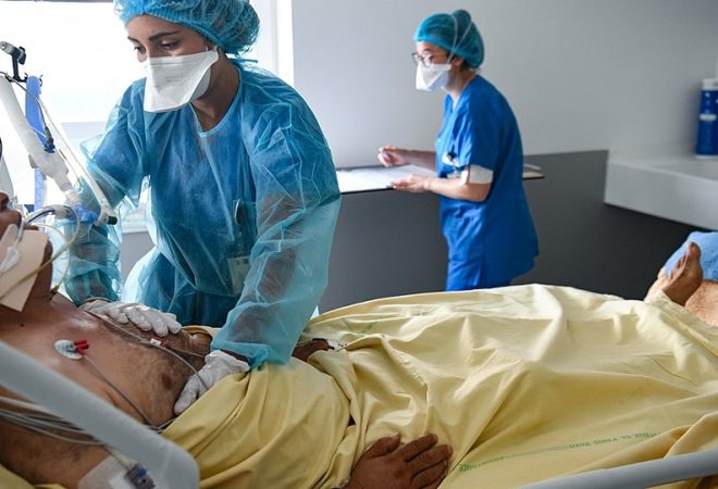 Medical staff members tend to a Covid-19 patient under respiratory assistance, in a room of the intensive care unit of the Henri Mondor Hospital in Creteil, near Paris, on July 22, 2021. (Photo by ALAIN JOCARD / AFP)