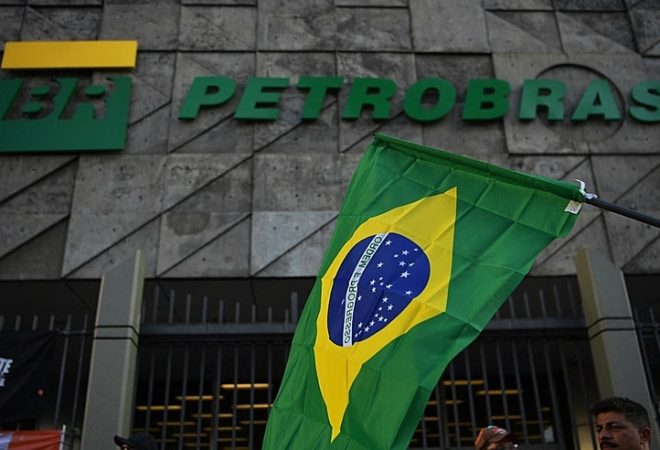 (FILES) In this file photo taken on February 18, 2020 a Brazilian flag is seen during a protest against layoffs outside Brazil's state-owned oil company Petrobras headquarters in Rio de Janeiro, Brazil. - Virtually headless for over a week, Brazil´s oil giant Petrobras goes through a moment of uncertainty after the scandal of the Lava Jato (Car Wash) investigation against corruption. (Photo by CARL DE SOUZA / AFP)