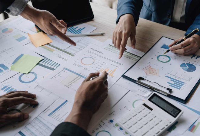 Business People Meeting using laptop computer,calculator,notebook,stock market chart paper for analysis Plans to improve quality next month. Conference Discussion Corporate Concept...