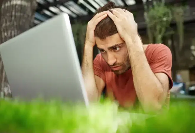 jovem-chateado-e-desapontado-olhando-triste-para-a-tela-do-laptop-sentado-ao-ar-livre_020620231554.jpg