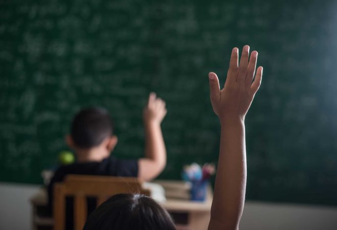 kid raising his hand in classroom