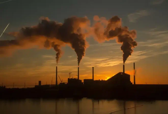 low-angle-shot-factory-with-smoke-steam-coming-out-chimneys-captured-sunset